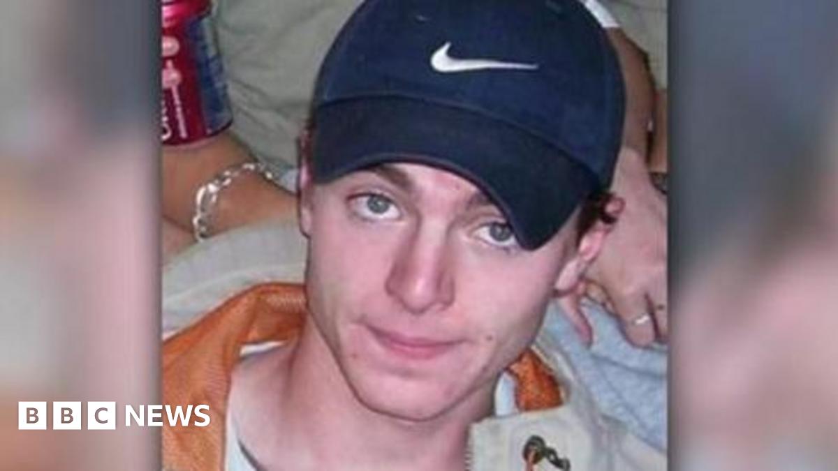A headshot image of Luke Durbin. A young man wearing a navy Nike baseball cap. He is smiling and looking directly into the camera.