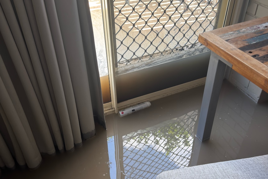 A room inside a house with water on the floor