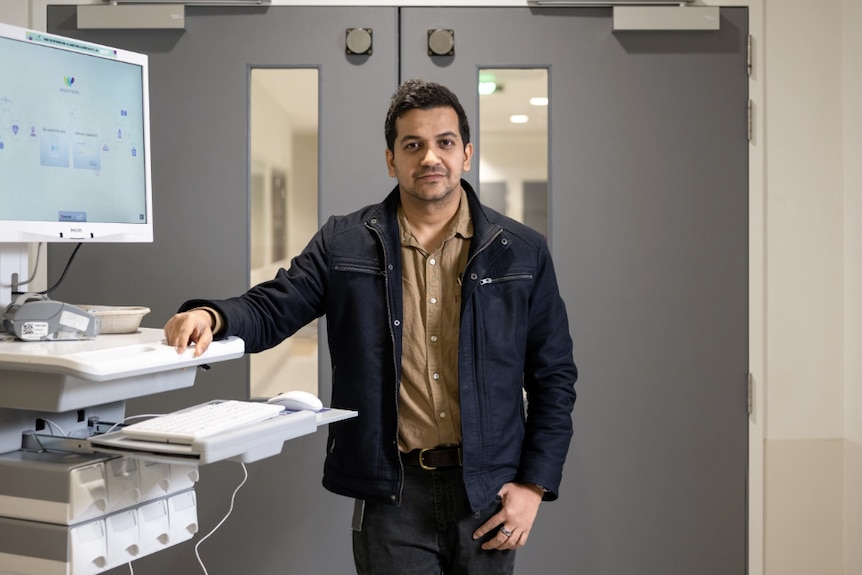 Dr Soumitra Das pictured next to a computer in a medical setting. 