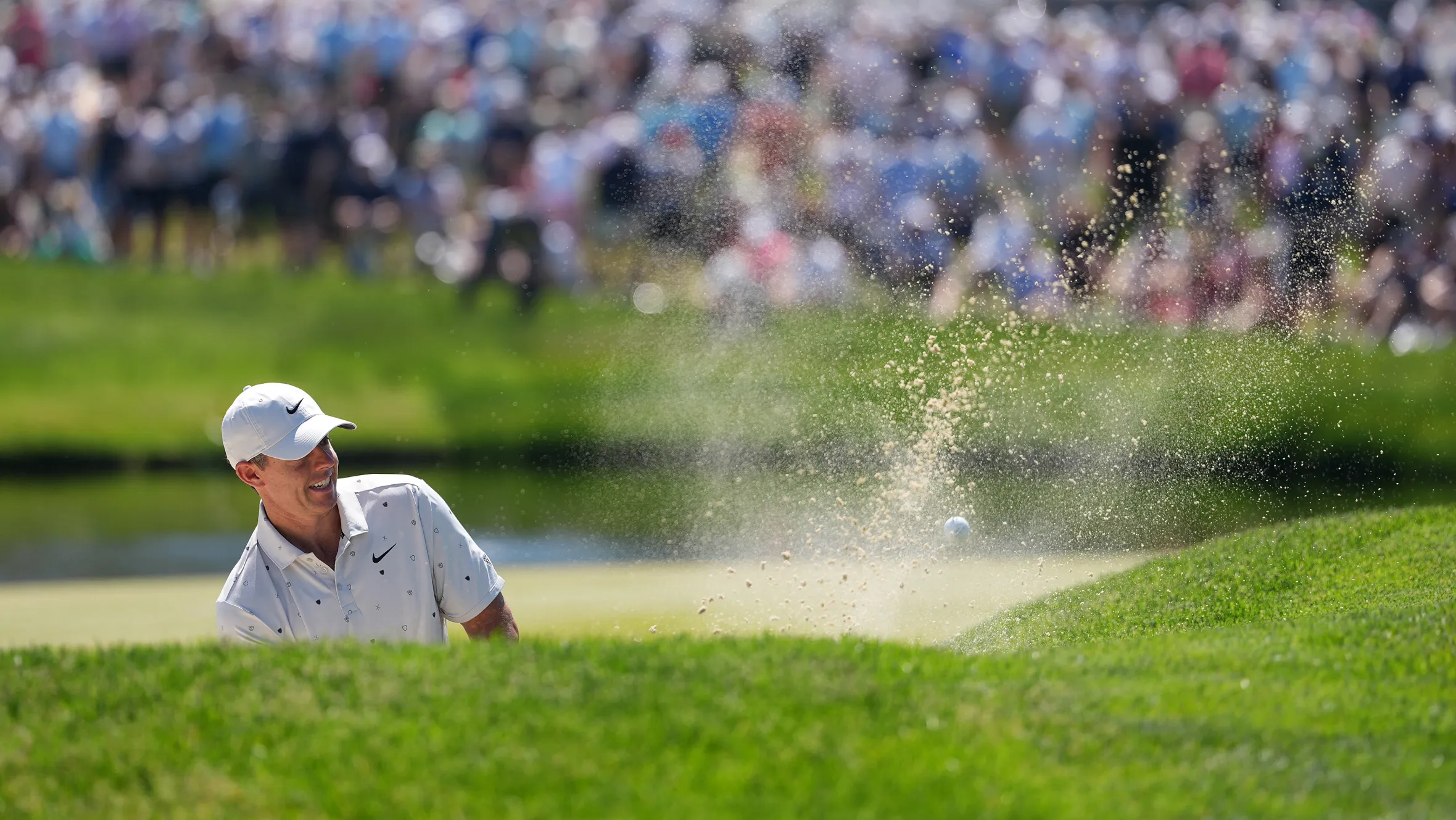 Rory McIlroy hits a golf ball from a sand trap, sending sand flying, during the PGA Championship.