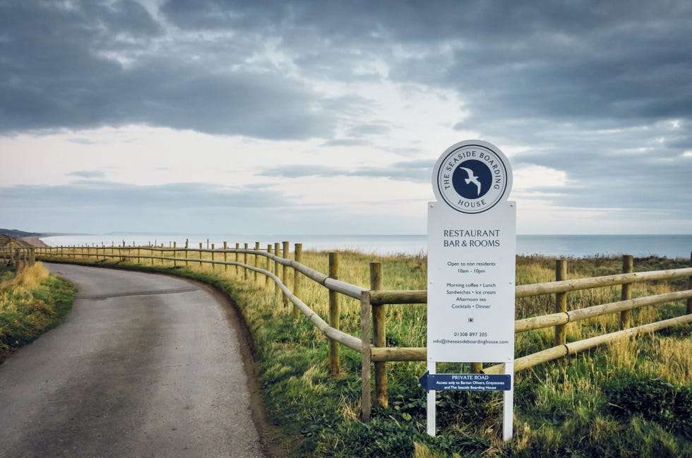 sign for a seaside restaurant and bar with a winding road leading to the ocean sign for a seaside restaurant and bar with a winding road leading to the ocean