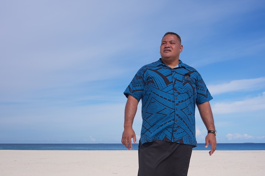 Tuvalu climate change minister Maina Talia stands on newly built land on the shoreline where his house used to sit.