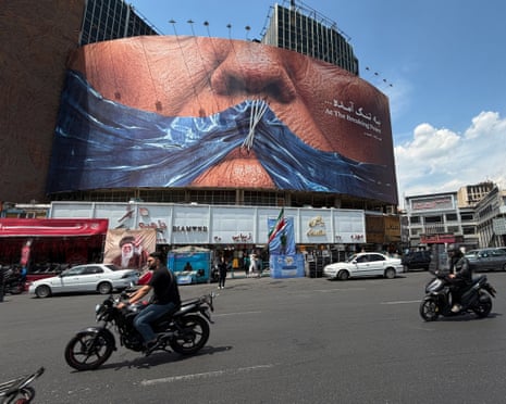 Vehicles drive past a billboard with an image of the strait of Hormuz and sewn lips of Donald Trump in a square in central Tehran, Iran, at the weekend