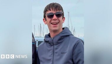 Hayden Davies smiles at the camera wearing sunglasses wearing normal civilian clothes in a photo taken before he was in Russian captivity.