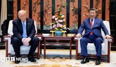 Xi and Trump walk under a decorated ceiling
