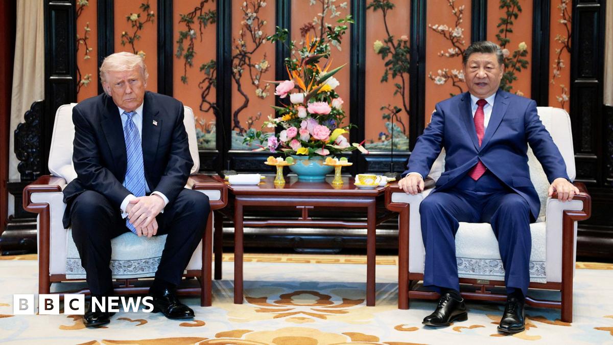 Xi and Trump walk under a decorated ceiling