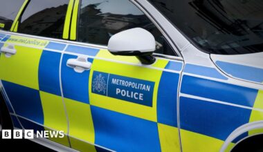 A police car with a Metropolitan Police log and blue and yellow chequerboard pattern on the side