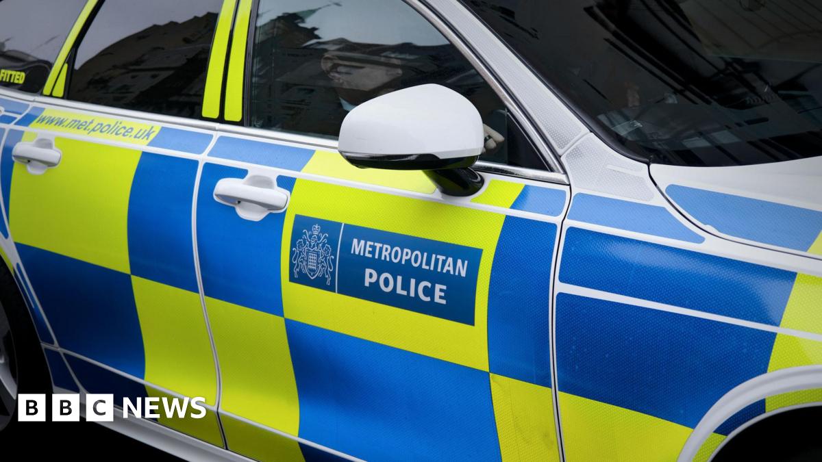 A police car with a Metropolitan Police log and blue and yellow chequerboard pattern on the side