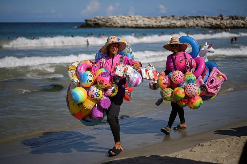 Vendors sell inflatable toys at the beach in La Guaira, Venezuela, December 27, 2025. REUTERS/Gaby Oraa