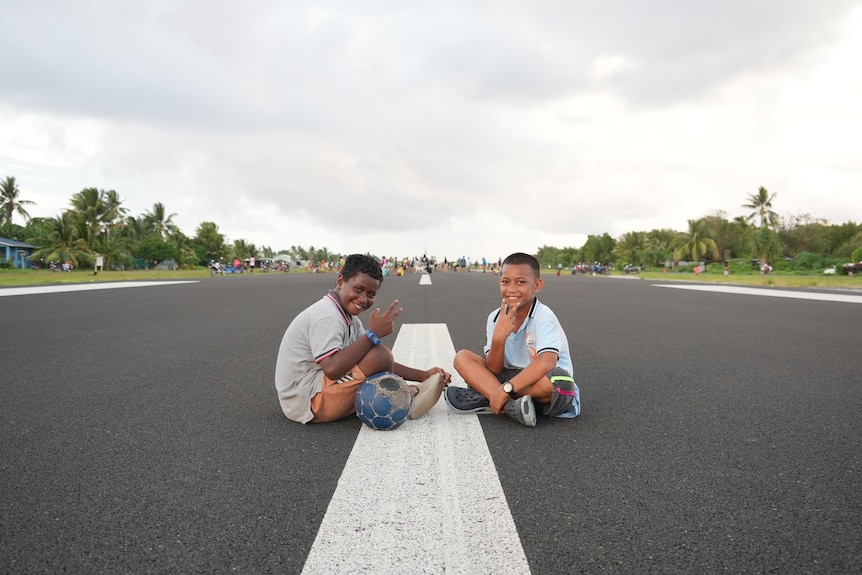 Kids playing on the airport runway in Tuvalu.
