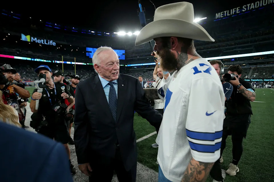 Dallas Cowboys owner Jerry Jones (left) greets American recording artist Post Malone on the field before a game against the New York Giants at MetLife Stadium.