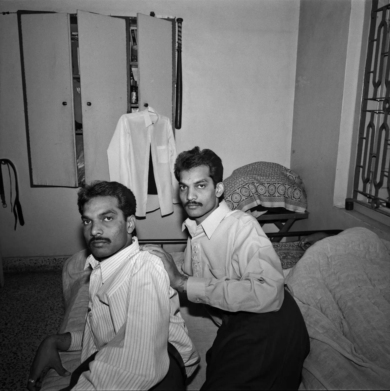 Two men, Milan and Mayur, sit together in a room in Gujarat.