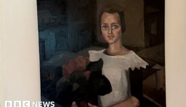 A painting believed to be Toon Kelder's 'Portrait of a Young Girl' shows a girl in a white dress with black sleeves holding what appears to be a bouquet of red flowers. She has brown hair and blue eyes and is sitting.