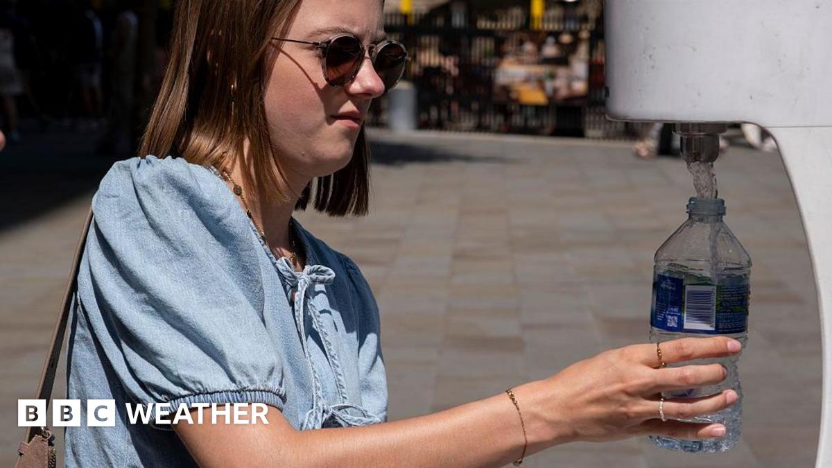 People using a water fountain to top up their water bottles in the Spring heat to keep cool and hydrated during the first heatwave of the year