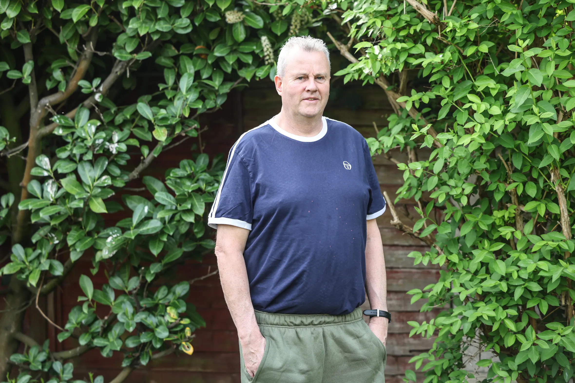 Former firefighter Martin O'Brien stands in his parents' garden.