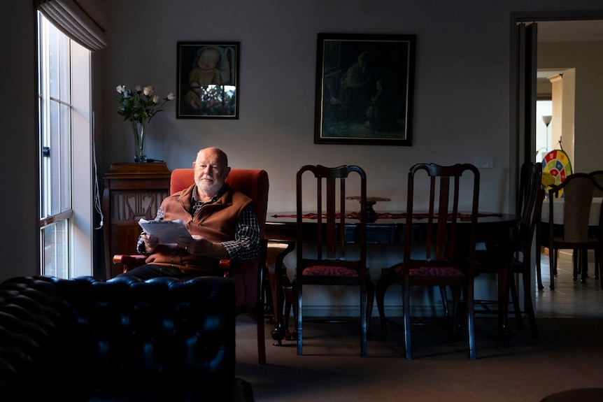 A older man sitting in his lounge room.