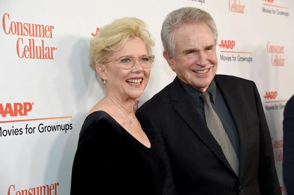 Annette Bening in a black dress stands next to husband Warren Beatty on the red carpet in 2020.