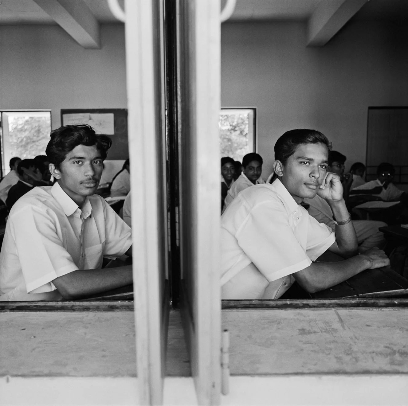 Two young men, Luv and Kush, sit in a classroom in Gujarat.