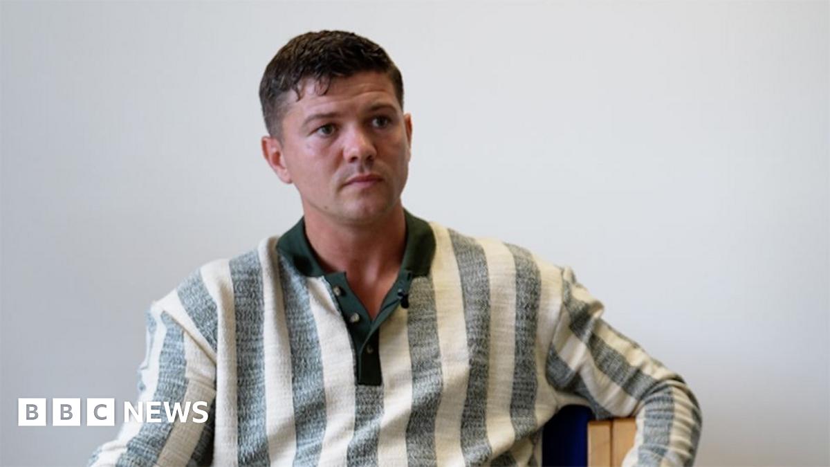 Luke Campbell he has short dark hair and is wearing a white and grey striped shirt