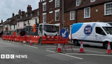 A van with the label Southern Water parked in front of a lorry. There are orange road blocks next to the vehicles.