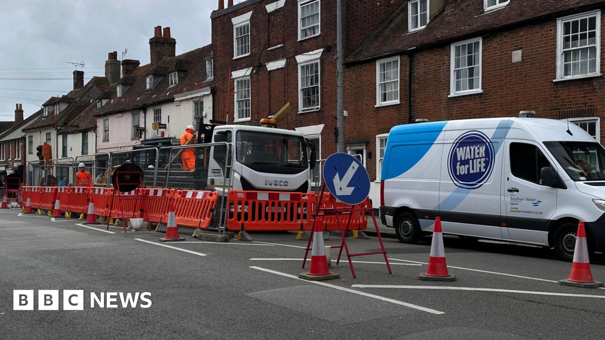 A van with the label Southern Water parked in front of a lorry. There are orange road blocks next to the vehicles.