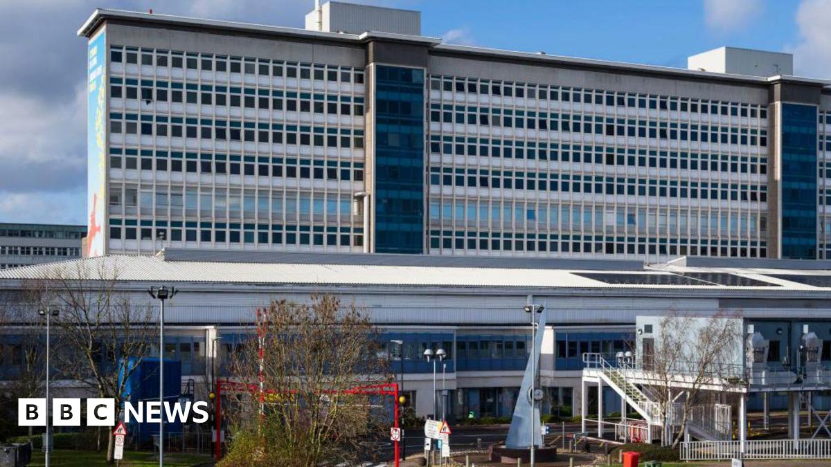 University Hospital Wales main building seen from the front outside. A large high-rise rectangular building rises up behind and a two-storey building is visible in front