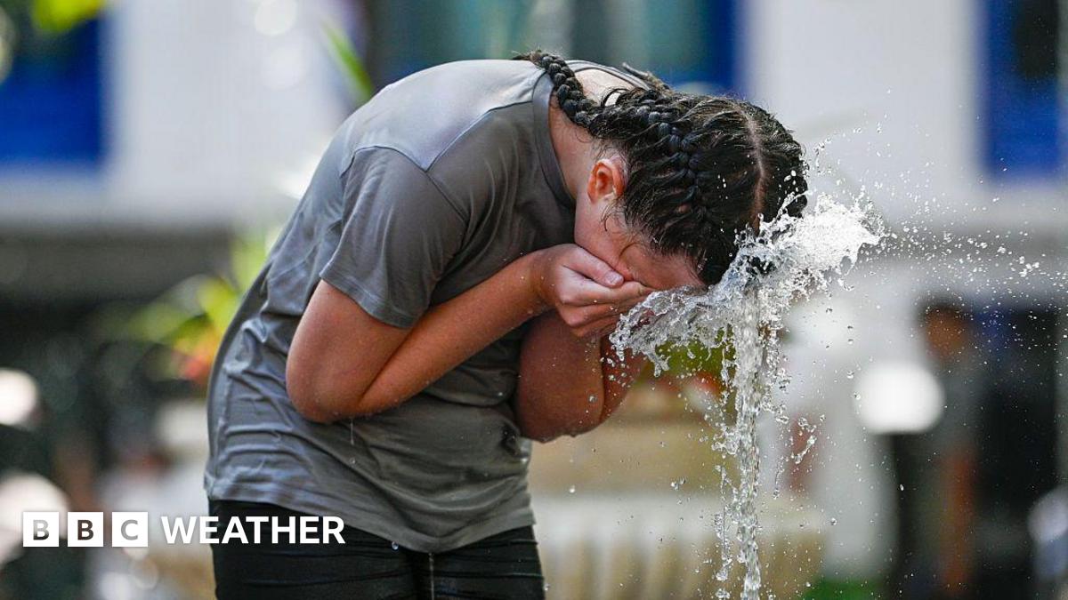 woman spashing water from a fountain on her face to cool down