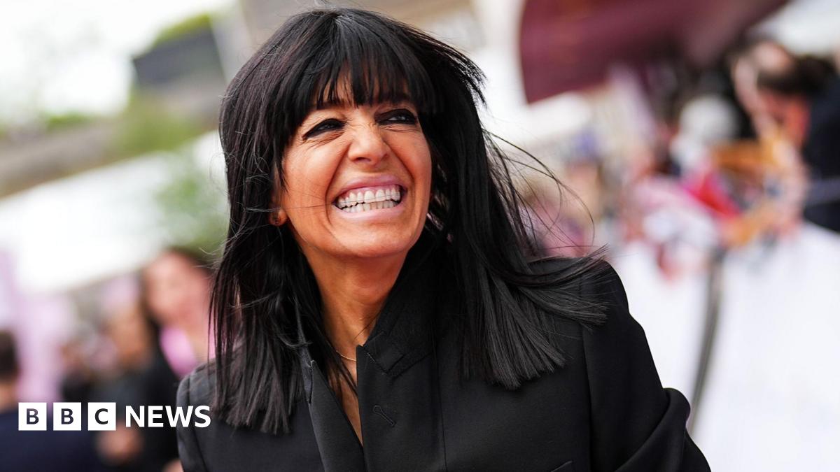 Claudia Winkleman smiling and holding hands with Kris Thykier