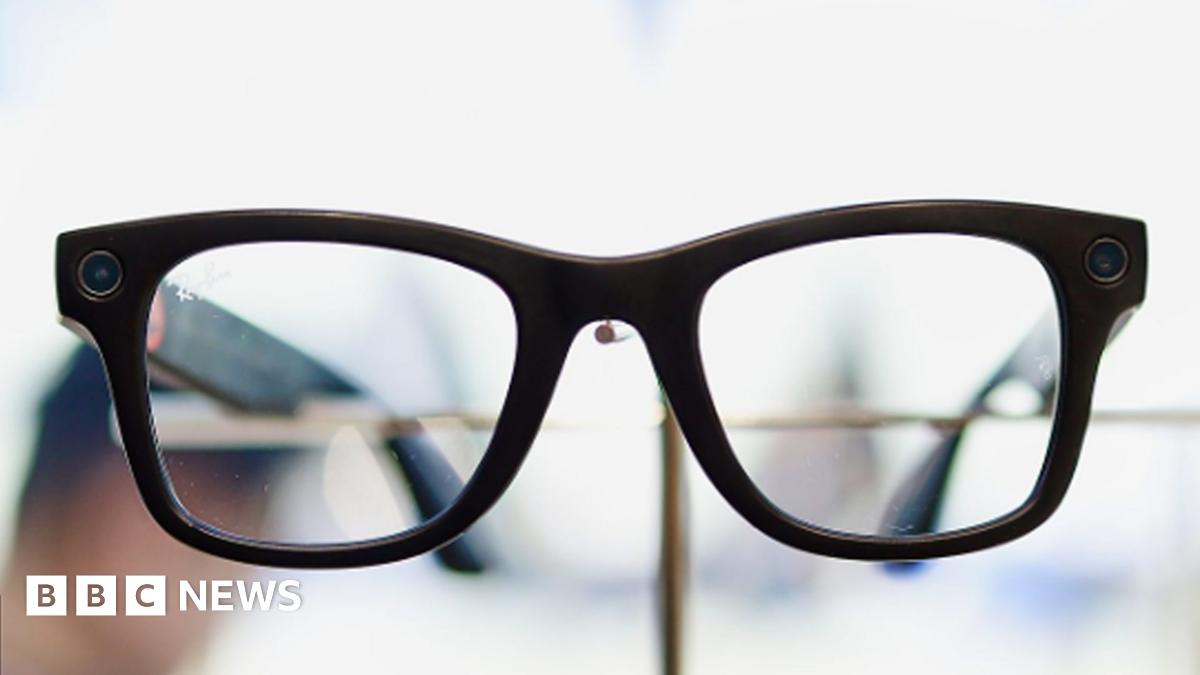 A woman wearing glasses sat on a bench.