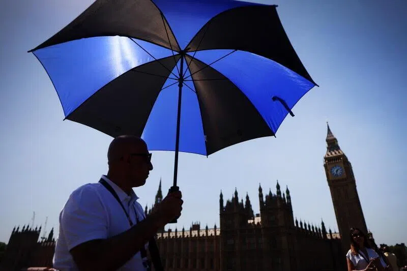 A pedestrian shelters from the sun on Westminster Bridge in London, on May 25. The UK has recorded it’s hottest May day on record, with temperatures hitting 34.8 deg C in parts of London.