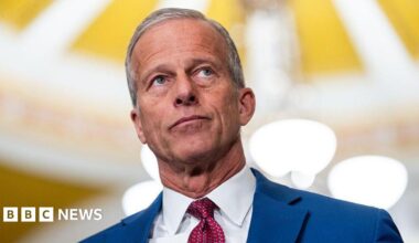 John Thune wearing a blue suit and red tie.