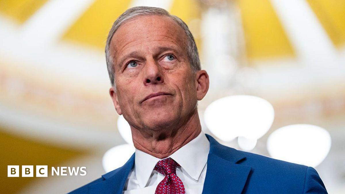 John Thune wearing a blue suit and red tie.
