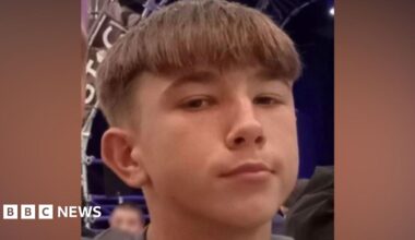 A teenager with short brown hair looks at the camera.