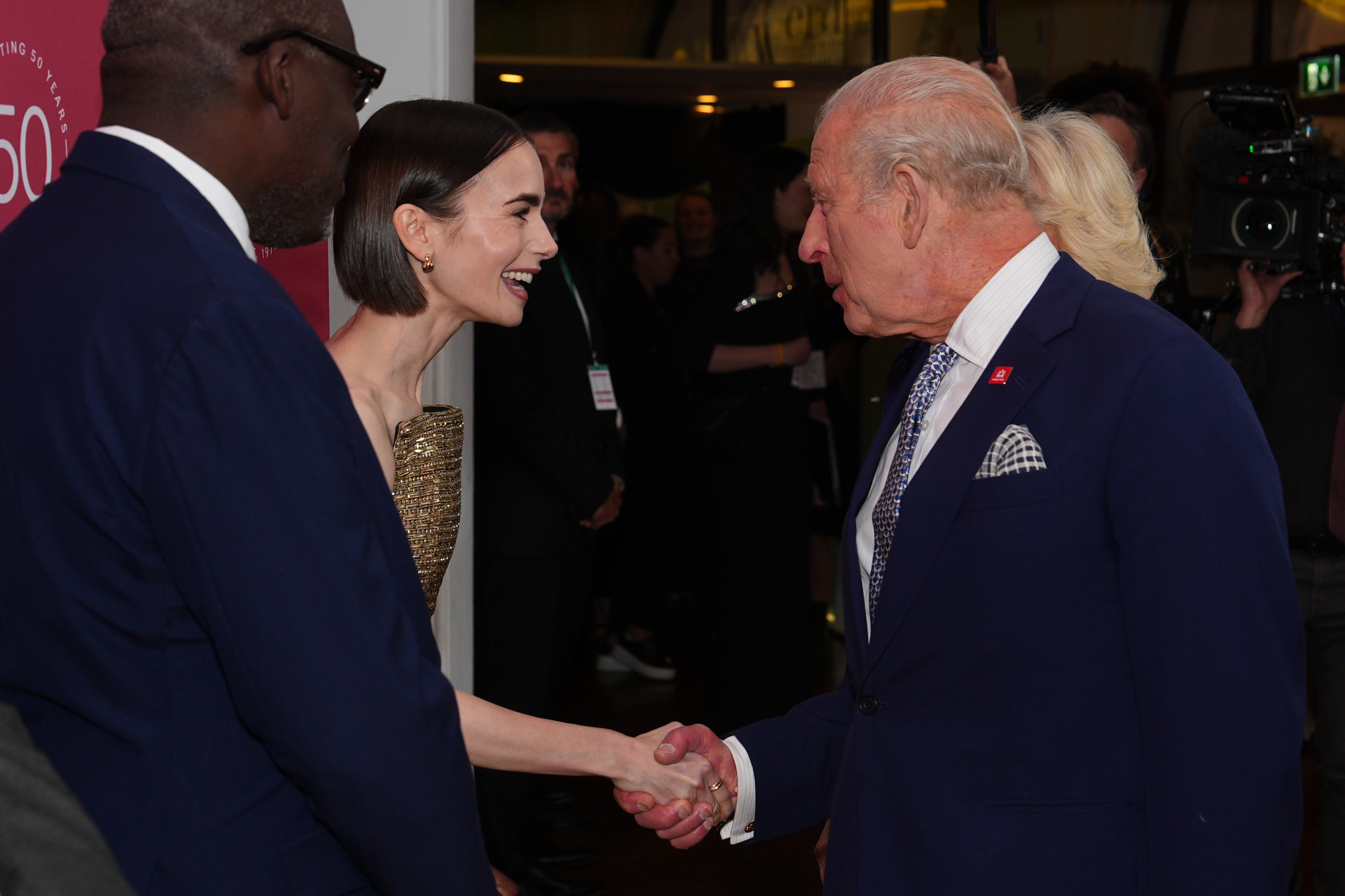 Lily Collins shakes hands with the King (Aaron Chown/PA)