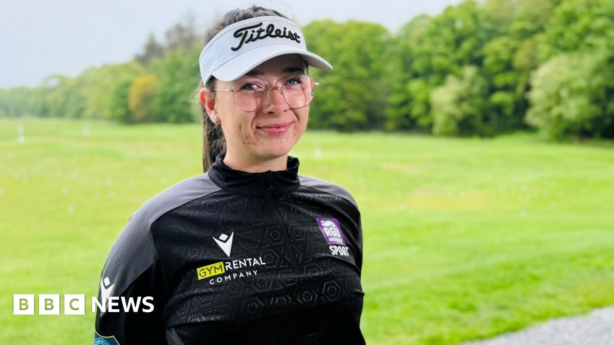 Amateur golfer Robyn Fowlie smiling at the camera at a golf driving range, she is wearing a branded golf hat.