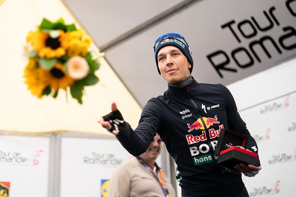 Second placed Red Bull BORA hansgrohe's German Florian Lipowitz, throws flowers during the podium ceremony of the final stage of the Tour of Romandie UCI cycling World tour, 178.2 km from Lucens and to Leysin, in Leysin, Switzerland, on May, 3, 2026. (Photo by TIL BUERGY / AFP via Getty Images)
