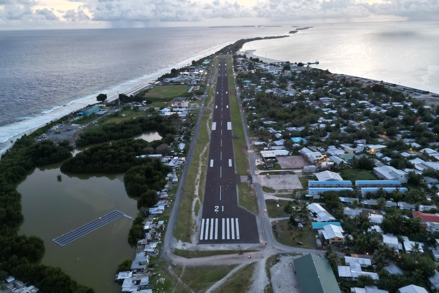 A drone shot of Tuvalu's only international runway surrounded by ocean.