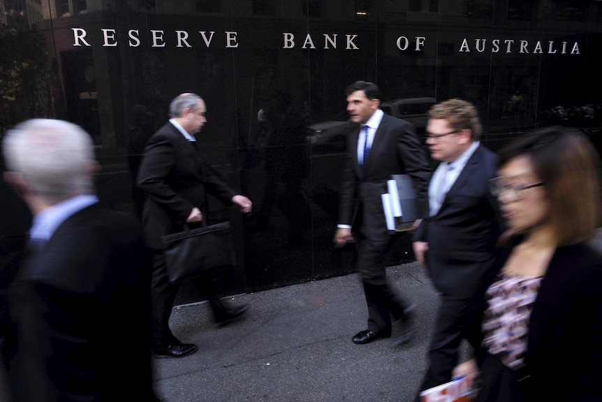 Business people walk outside the Reserve Bank of Australia (RBA) in Sydney