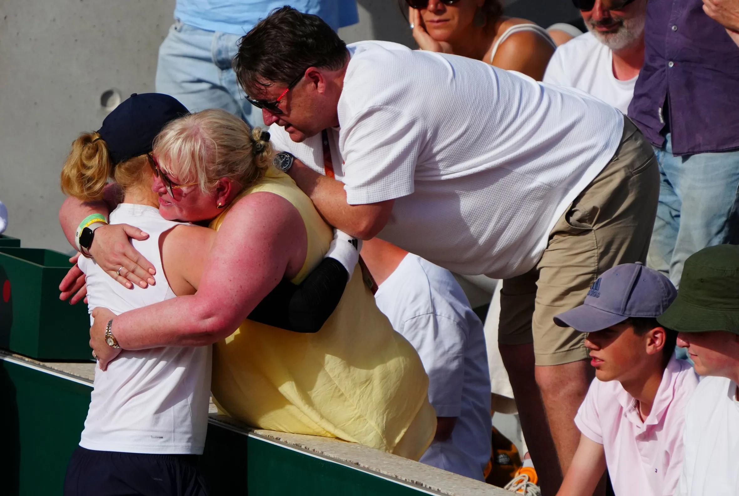 Francesca Jones embraces her parents after winning her first round match at the French Open.
