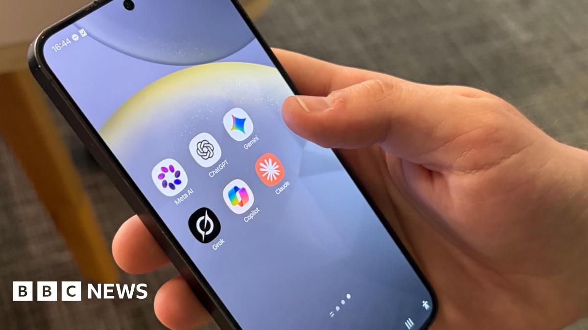A hand holding a black mobile phone with six apps on the screen: Meta AI, ChatGPT, Gemini, Grok, Copilot, Claude.