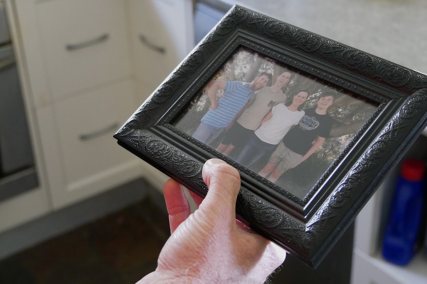 A man holding a family photo.