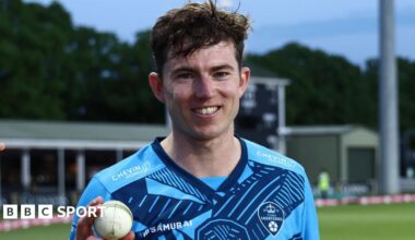 Martin Andersson wearing a blue shirt holds a white ball in his right hand as he smiles to the camera
