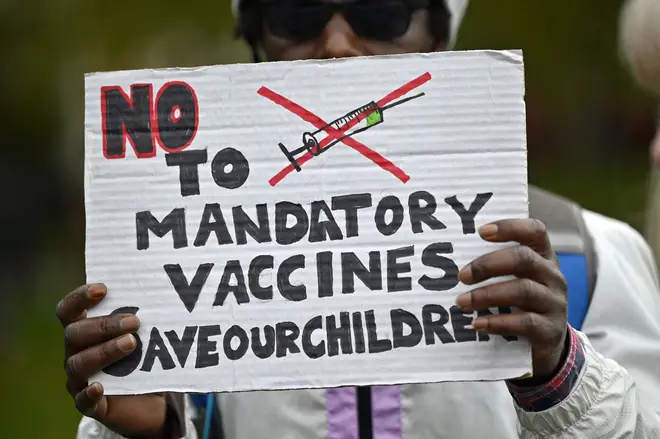 A protester holds up a placard at a demonstration against vaccinations and government restrictions designed to fight the spread of coronavirus in 2020