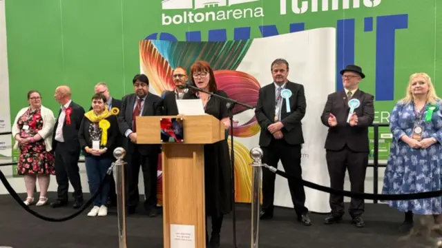 People on stage in an arena in Bolton