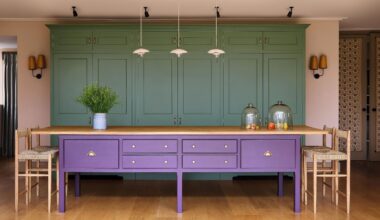 a green and kitchen with a large purple island with oak kitchen steels and a trio of pendant lights above