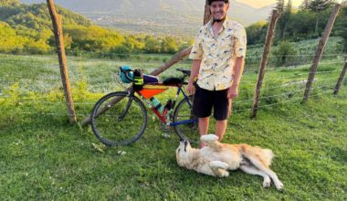 Andrew with his bike, and a new canine friend