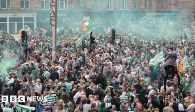 Hundreds of Celtic fans on city streets in Glasgow, letting off smoke bombs and climbing up lamp posts as they celebrate their side winning the league title.
