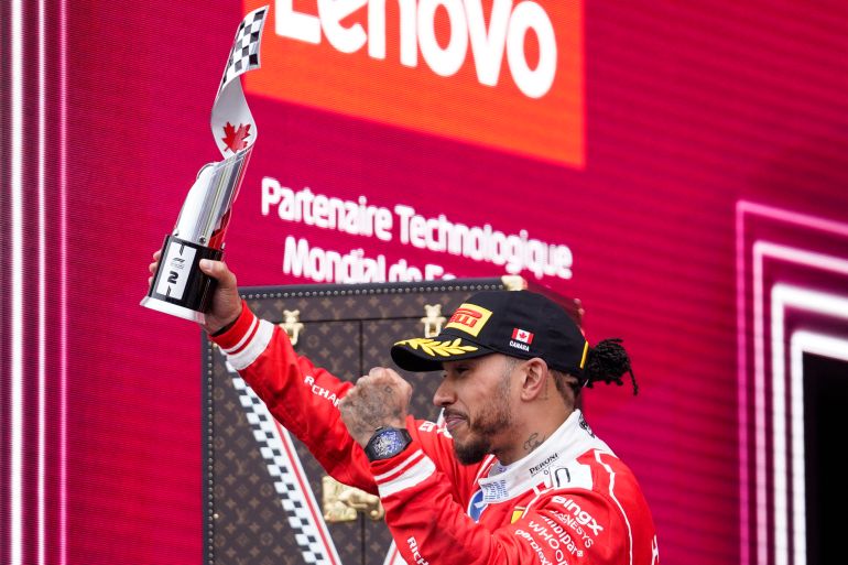 Ferrari's British driver Lewis Hamilton holds his second place trophy as he celebrates on the podium at the conclusion of the 2026 Formula 1 Grand Prix du Canada at Circuit Gilles-Villeneuve in Montreal, Canada, on May 24, 2026. (Photo by Geoff Robins / AFP)