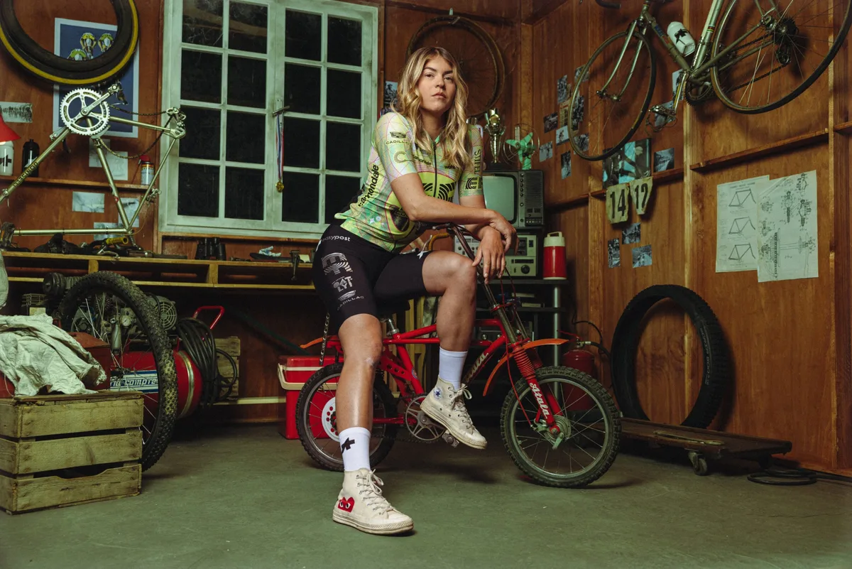 Woman wearing EF Pro Cycling Giro d'Italia kit posing on bike.