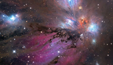 A starfield surrounds a colorful nebula that
glows both red and blue but is filled with dust, both 
light brown and dark brown. 
Please see the explanation for more detailed information.